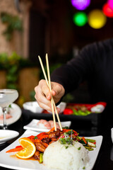 Chopsticks reaching for orange chicken 