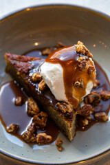 Overhead shot of toffee pudding cake with ice cream and caramel sauce 