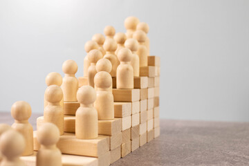 silhouette of an office worker with a suitcase climbs the stairs. gears on a wooden background.