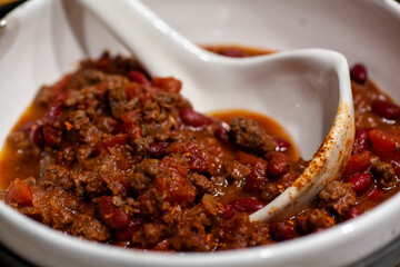 Homemade chili dinner with cornbread and ingredients.