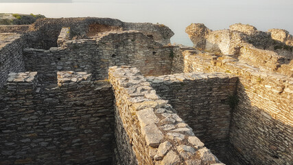 The ruins of an ancient Roman villa surrounded by an olive grille in the city of Sirmione...