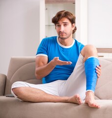 Obraz na płótnie Canvas Leg injured young man on the sofa