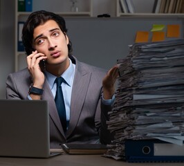 Young male employee working late at office