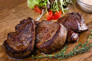 Meat medallions with sauce and greens, close-up