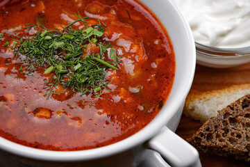 Solyanka with sour cream and herbs, close-up