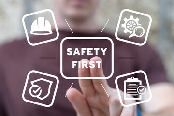 Employee using virtual touch interface presses inscription: SAFETY FIRST. Safety first, work safety, caution work hazards, danger surveillance, zero accident concept. Employees safety awareness.