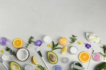 Flat lay composition with homemade cosmetic products and fresh ingredients on light grey background. Space for text