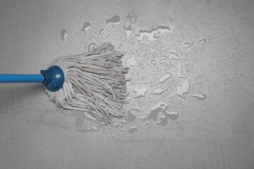 Cleaning grey floor with mop, top view. Space for text