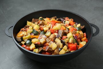 Delicious ratatouille in baking dish on grey table, closeup