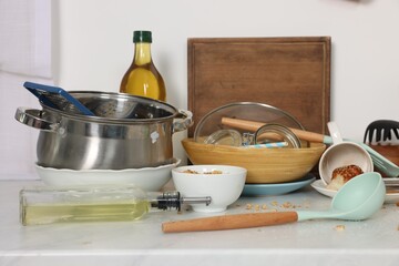 Messy countertop with many dirty utensils, dishware and food leftovers in kitchen