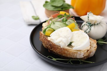 Tasty sandwich with burrata cheese, prosciutto and vegetables on white table, closeup