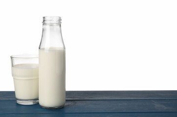 Glassware with tasty milk on blue wooden table against white background