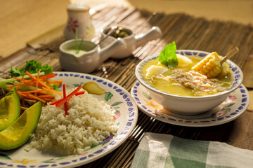 Traditional Colombian Ajiaco soup with chicken, corn, and avocado