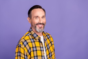 Portrait of satisfied person with stylish gray beard dressed checkered shirt toothy smiling at camera isolated on violet color background