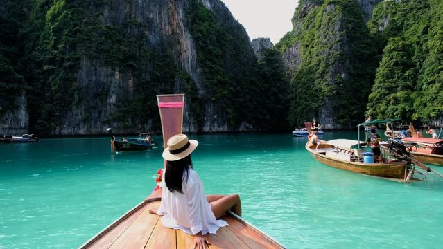 Women in front of a Longtail boat at the lagoon of Koh Phi Phi Thailand. Pileh Lagoon Thailand Thai women in front of a Longtail boat in Thailand. 