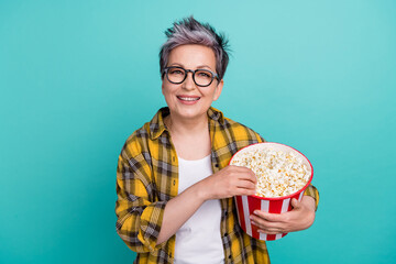 Photo of charming grandmother hold bucket popcorn eating dressed stylish checkered yellow outfit...