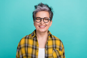 Photo portrait of charming grandmother toothy beaming smile wear trendy plaid yellow outfit isolated on cyan color background