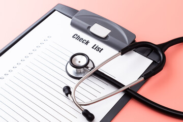 ピンク背景に聴診器とチェックリスト