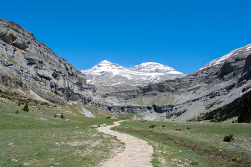 Senda discurriendo entre montañas con paisaje montañoso y nieve
