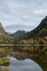 Árboles en otoño reflejados en lago de montaña