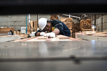 Black man wood factory worker working with wood plank in carpentry workplace