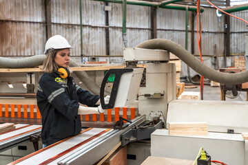 Wood factory engineer woman working and controlling machine in manufacturing factory