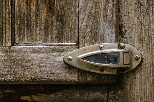 Estamos viendo una vieja puerta de heladera comercial muy antigua , con hermoso herraje y texturas quebrajadas por el paso del tiempo.