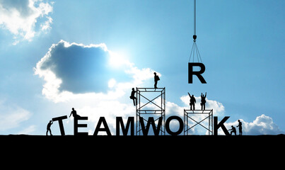 Silhouette of construction workers as a team working together to put letters as a word teamwork on a bright sky background - obrazy, fototapety, plakaty