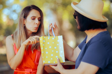 Woman Checking the Present She Receives from her Mother. Unthankful daughter reacting badly to her...