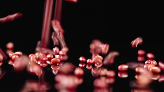Falling of grain red beans or azuki beans
in slow motion,on a black background. 