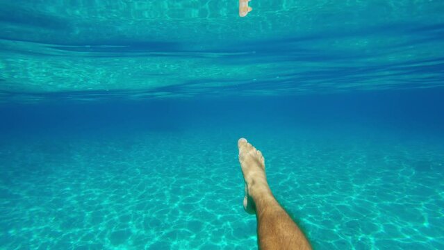POV shot of swimming underwater in crystal clear emerald water sea, Sardegna, Italy