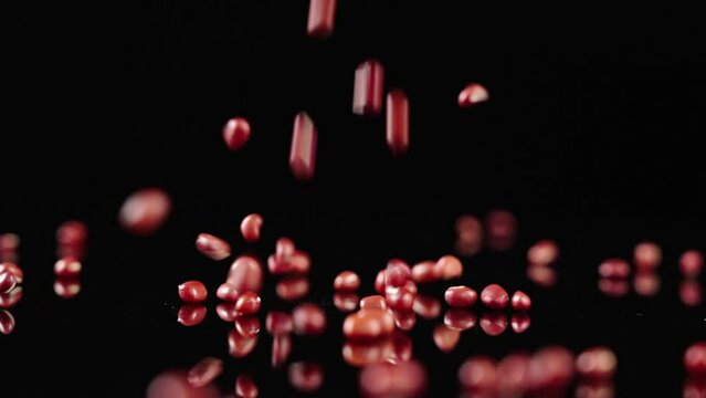 Falling of grain red beans or azuki beans
in slow motion,on a black background. 