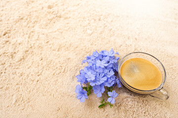 Obraz na płótnie Canvas Selective focus blue flowers and espresso on sand beach.