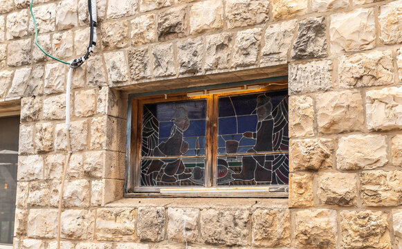 Colored stained glass window in stone wall window made by a local artist in the famous artists village Ein Hod near Haifa in northern Israel
