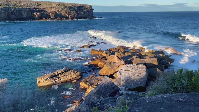 4k Video -Large waves crashing on the rocks in Royal National Park on the spectacular coastal walk at Wattamolla's Providential Point Lookout -South of Sydney, NSW, Australia.