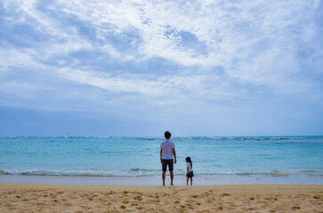 ビーチにたたずむ親子