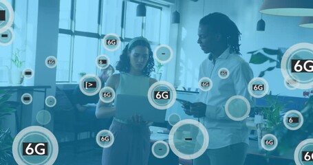 Animation of 6g text in circles over diverse coworkers standing and discussing reports on laptop - Powered by Adobe