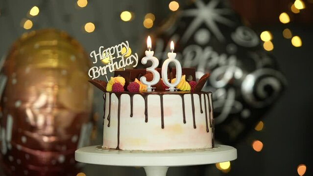 30th Birthday Cake candles lit by a man