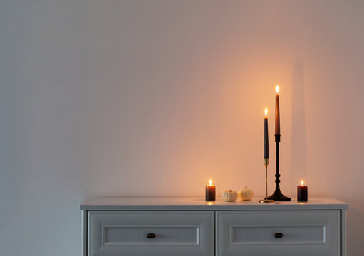 burning candles on white wooden shelf in white interior