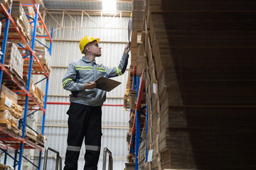 Male warehouse worker working and inspecting quality of cardboard in corrugated carton boxes warehouse storage. Male warehouse worker inspecting quality of barcodes on shelves pallet in warehouse