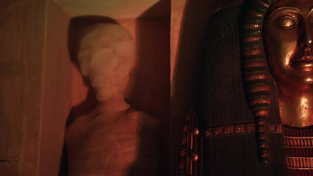 An Egyptian sarcophagus opening to reveal a mummy inside a tomb in Egypt