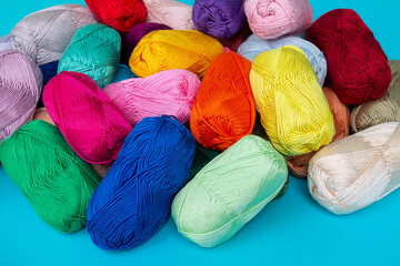 Randomly scattered multi-colored skeins of cotton yarn. Materials for knitting. Textile industry. Small depth of field.