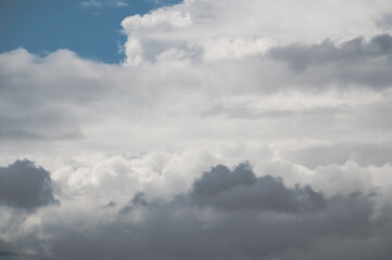 Dynamically changing and diverse layers of white clouds over the city. The clouds move quickly from left to right.