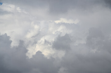 Dynamically changing and diverse layers of white clouds over the city. The clouds move quickly from left to right.