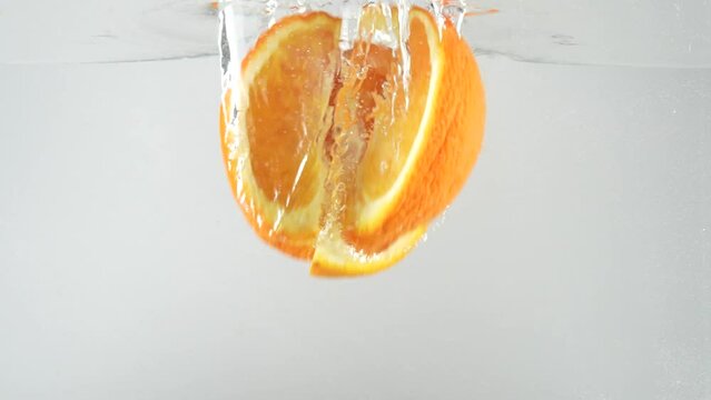 Orange Slices Falling into Water in slow motion