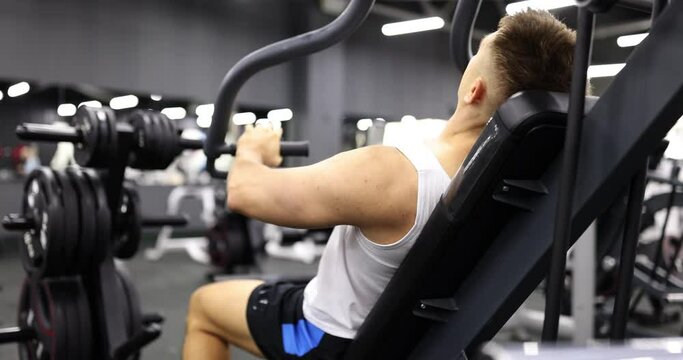 Athlete trains arms on simulators lying in gym. Sport health and workout motivation