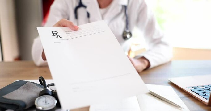 Doctor holds and gives prescription to patient closeup. Panacea and prescription of treatment