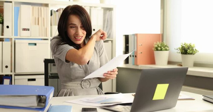 Beautiful business woman sits in office coughing and sneezing in elbow and correct behavior due to non-spreading viral infection. Unhealthy young woman feeling unwell at work