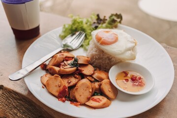 Thai Rice topped with stir-fried sausages and basil.