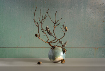 Composition with a dried branch and pine cones in a minimalist style.